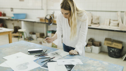 female-artist-working-with-sketches-white-paper